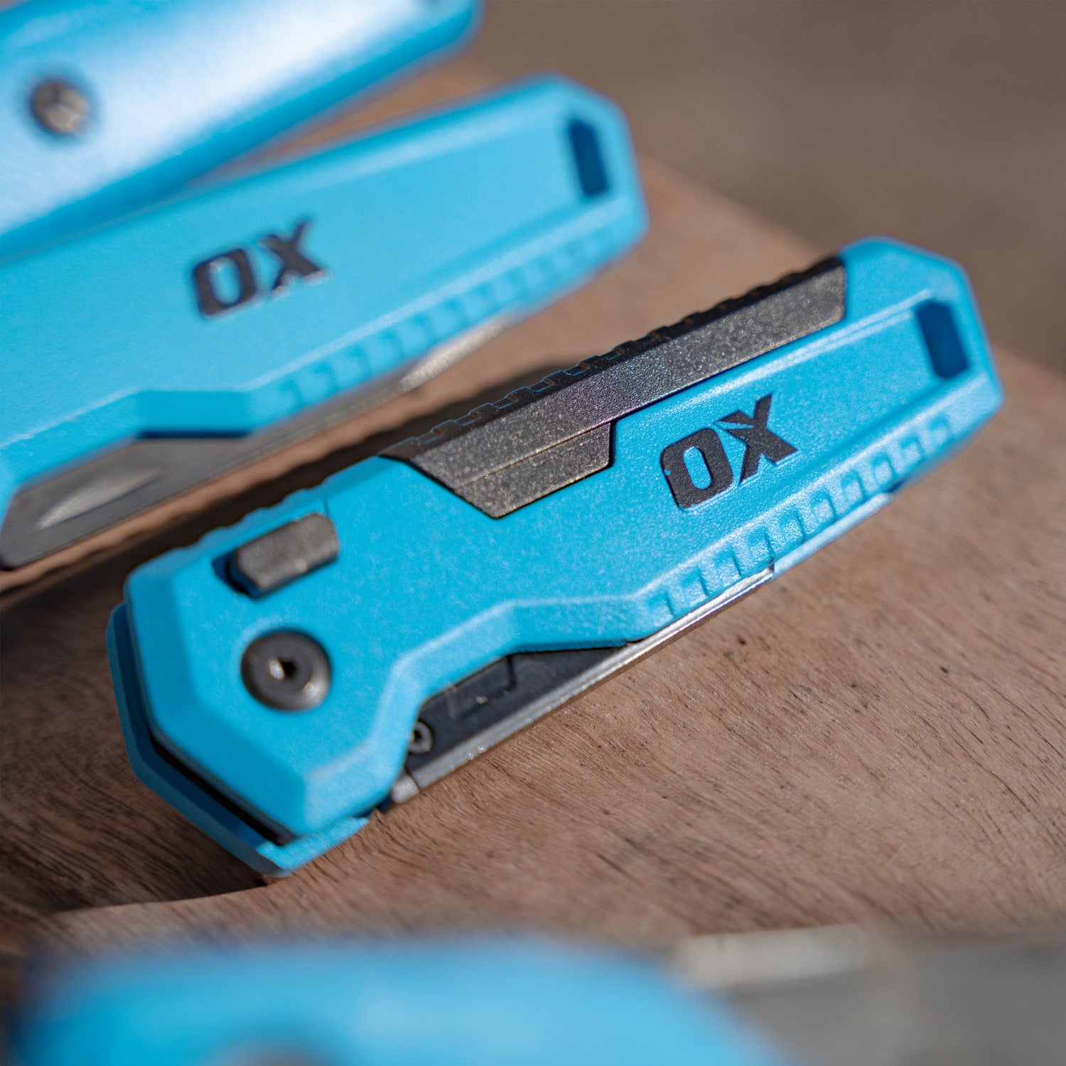 Cutter pliabil OX PRO — detaliu mâner, buton de eliberare și clemă