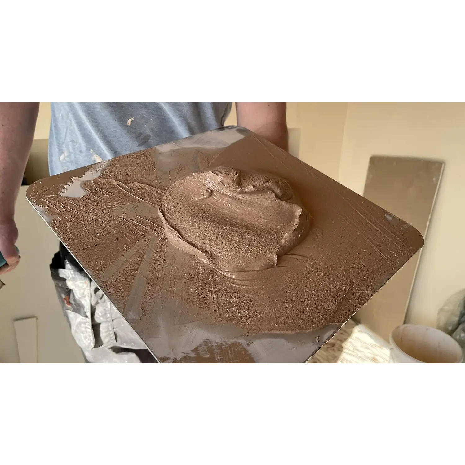 Imagine cu o persoană ce ține o mistrie de glet cu amestec de ipsos maro inalta calitate din aluminiu temperat OX PRO Hawk