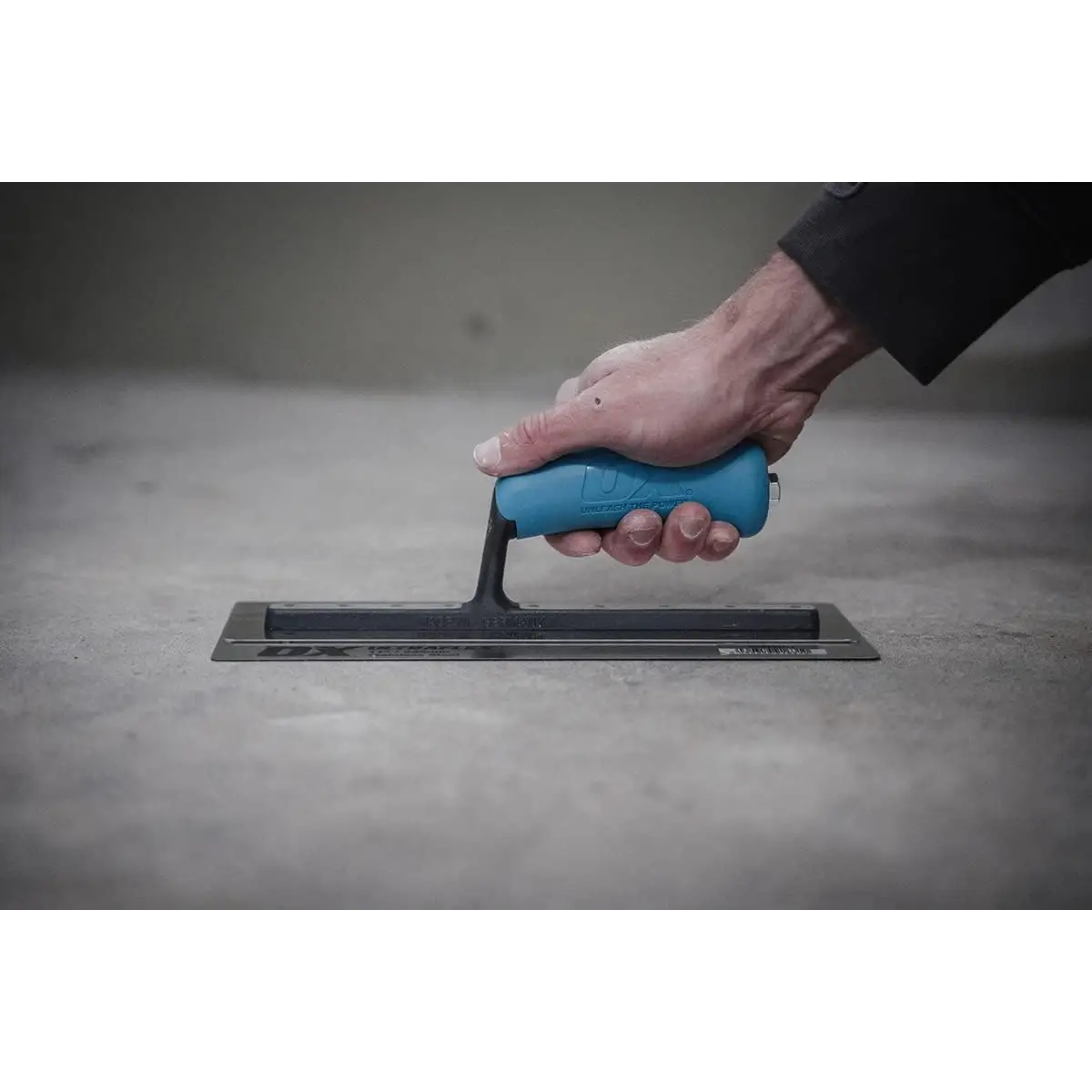 Mână ținând o gletieră Pro Ultraflex cu lamă ultraflexibilă și mâner ergonomic