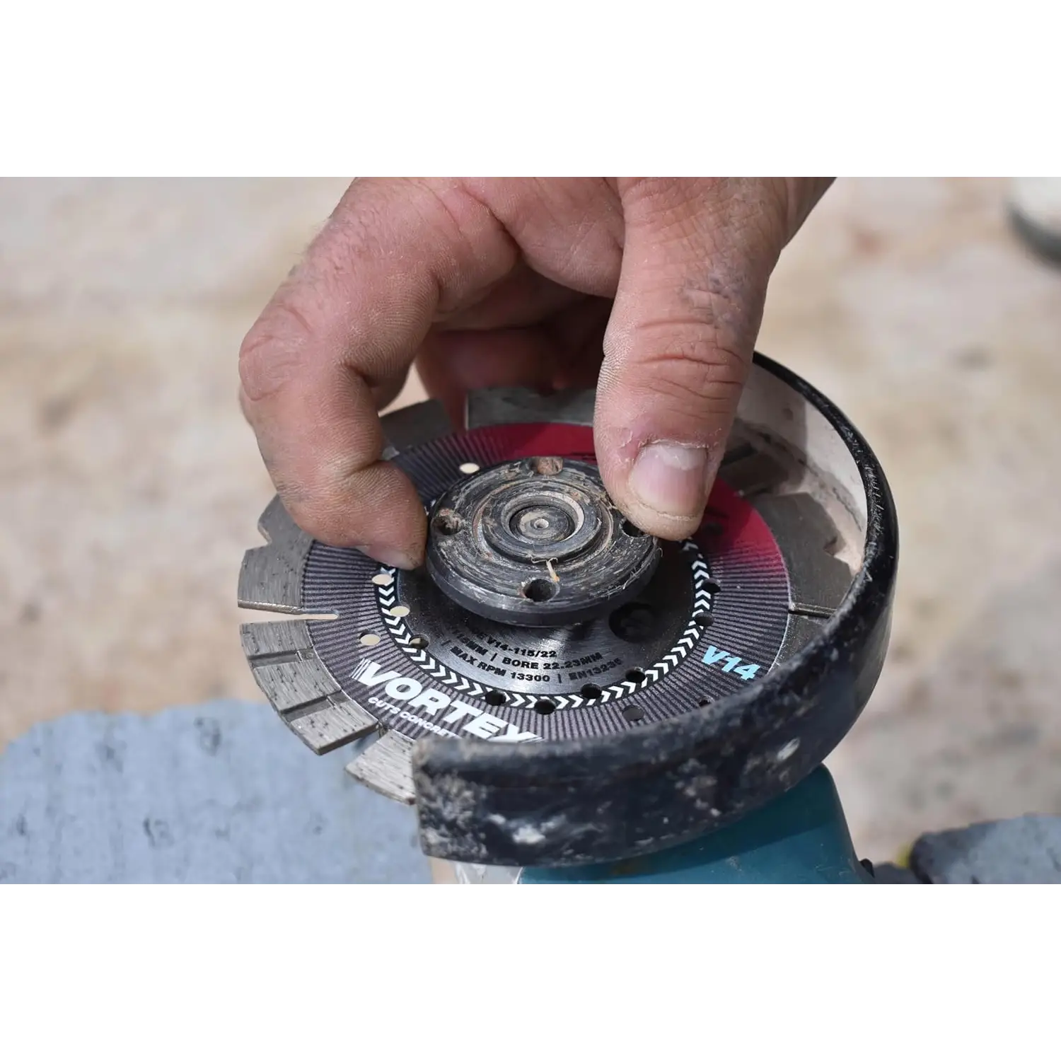 Mână ajustând discul diamantat Spectrum Pro V14 pe un flex, pentru tăiere beton armat