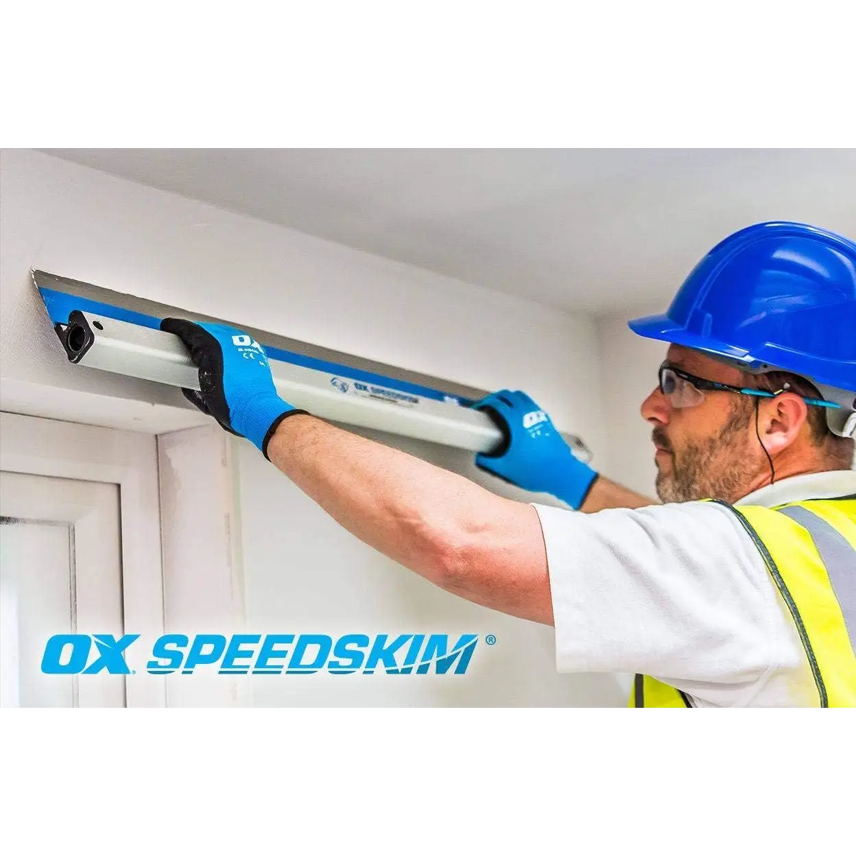 Muncitor cu cască albastră și vestă de vizibilitate folosind speedskim sf gletiera pentru finisare