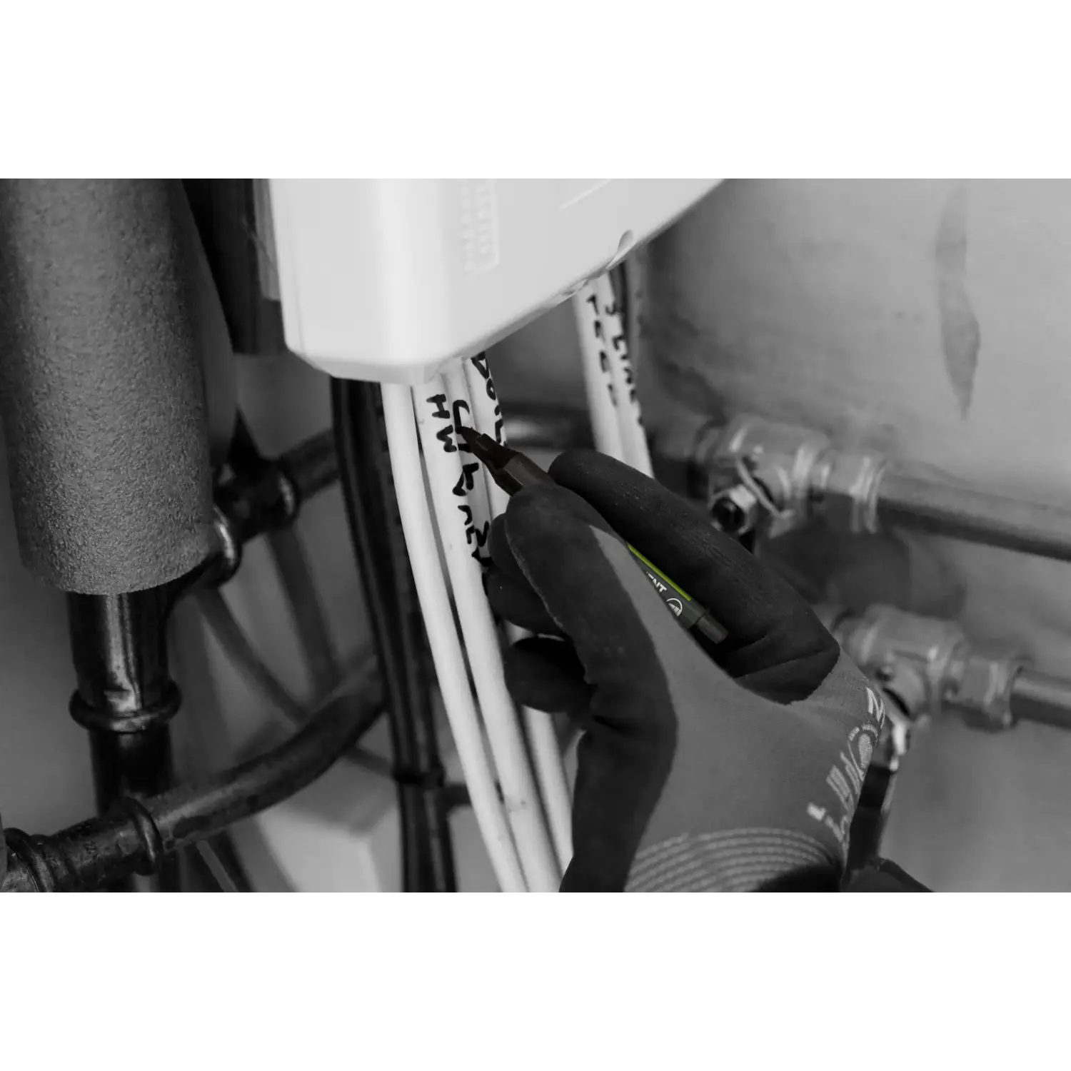 Mână glovată marcând fire cu marker permanent mini negru pentru DIY și construcții