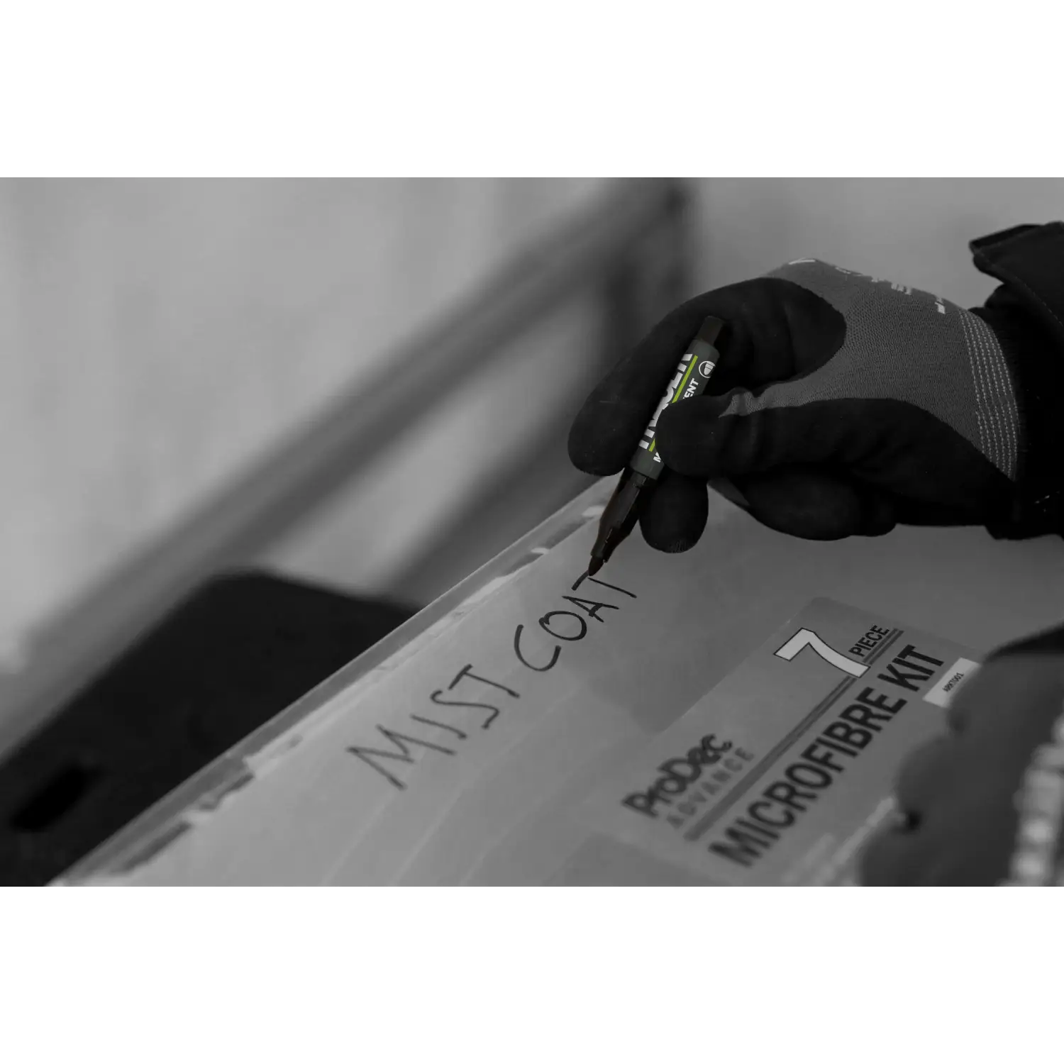 Persoană purtând mănuși scriind pe cutie cu markere permanente mini negre TRACER