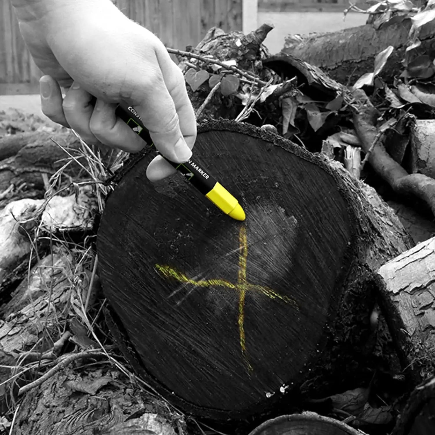 Persoană desenând o cruce galbenă pe buturugă cu markerul Tracer ofera marcare universala