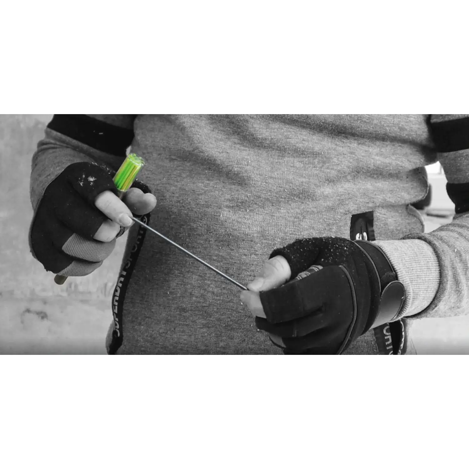 Persoană cu mănuși fără deget, ținând o tijă metalică cu vârf verde pentru markerul deep pencil