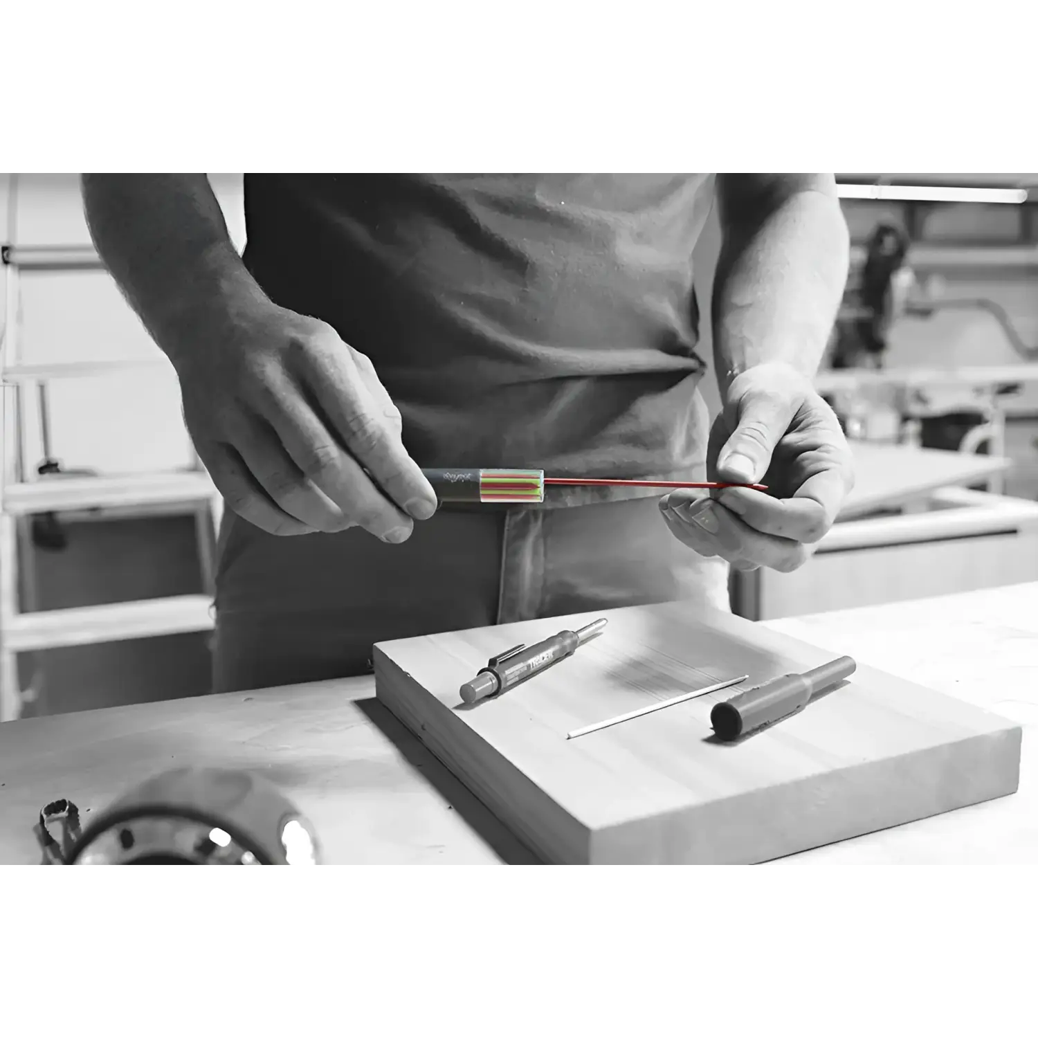 Mani ținând un fir roșu subțire dintr-un tub întunecat, pentru tracer deep hole