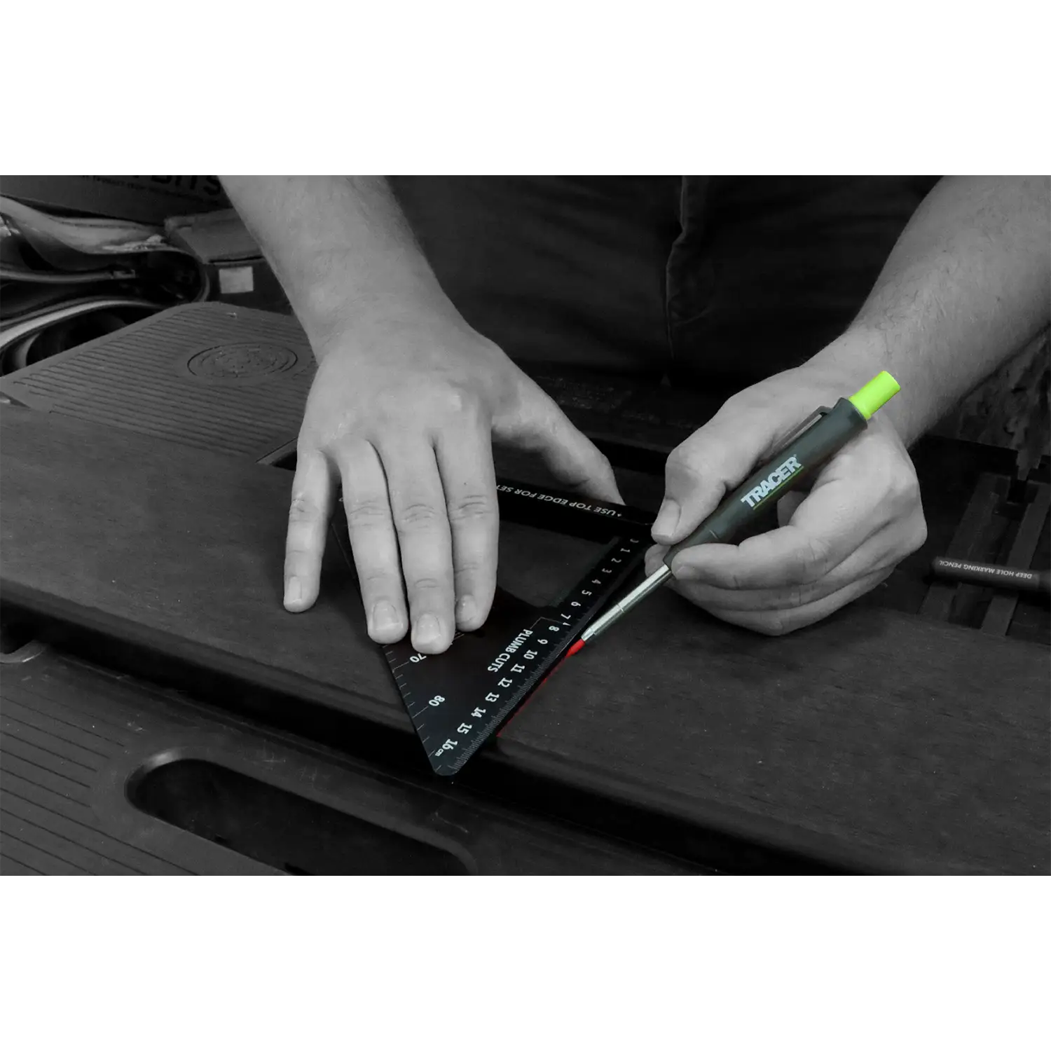 Mână folosind o riglă de măsurare neagră și un instrument de marcare verde pentru tracere deep hole pe o suprafață întunecată