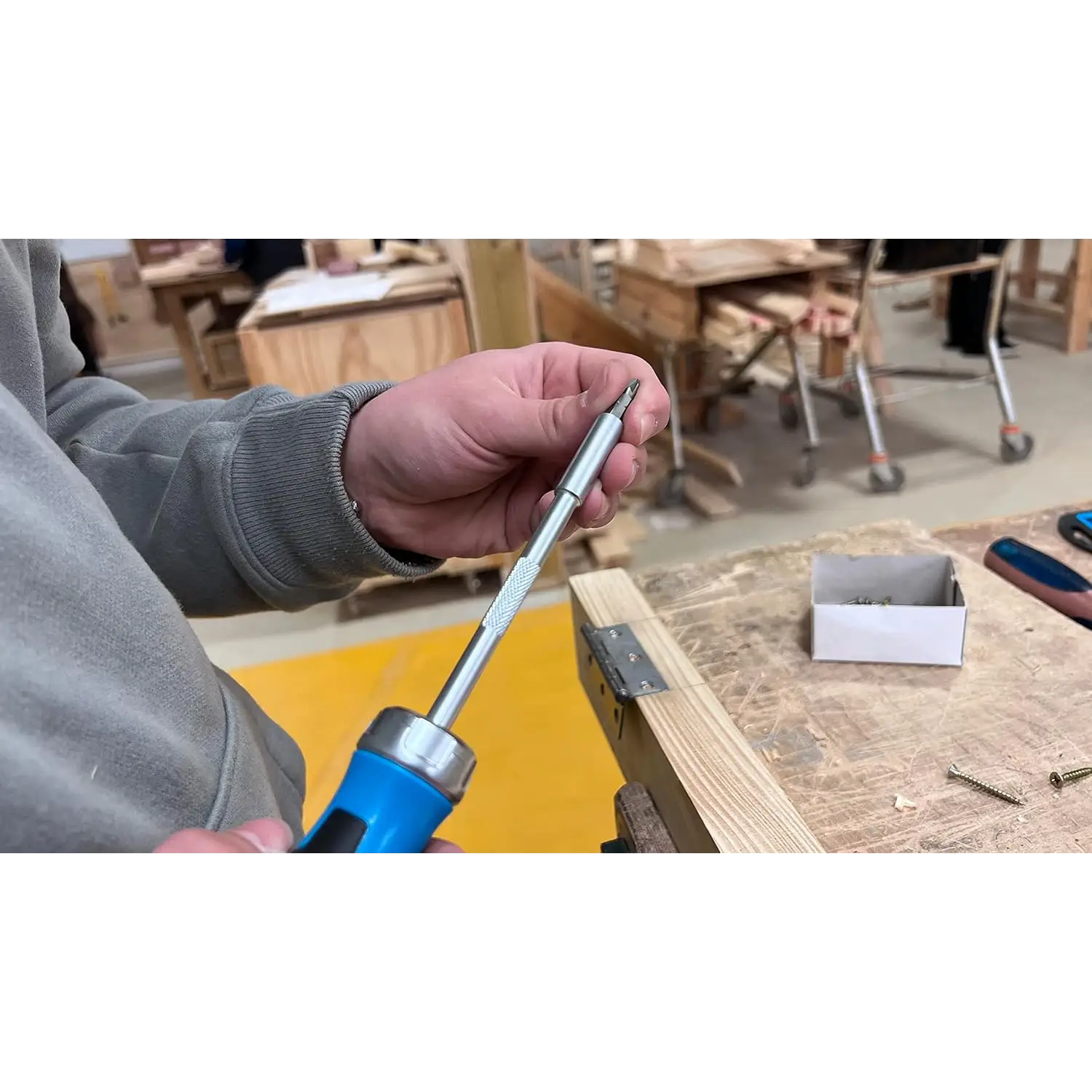 Mână ținând surubelnita cu clichet OX Pro, magazie în maner, ratchet blocabil