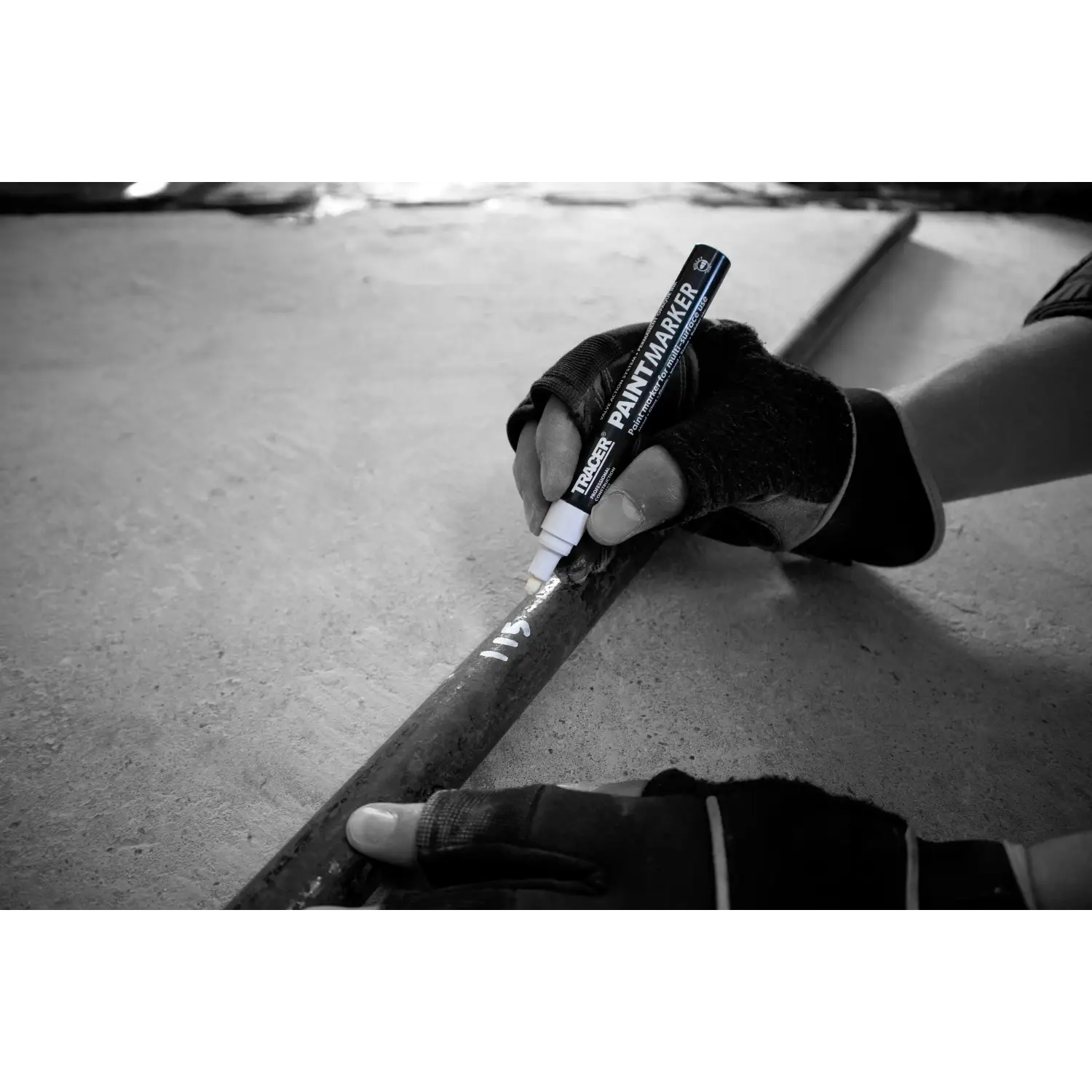 Mână ținând un marker tracer aptm2 pentru dulgheri și tâmplari cu vopsea albă