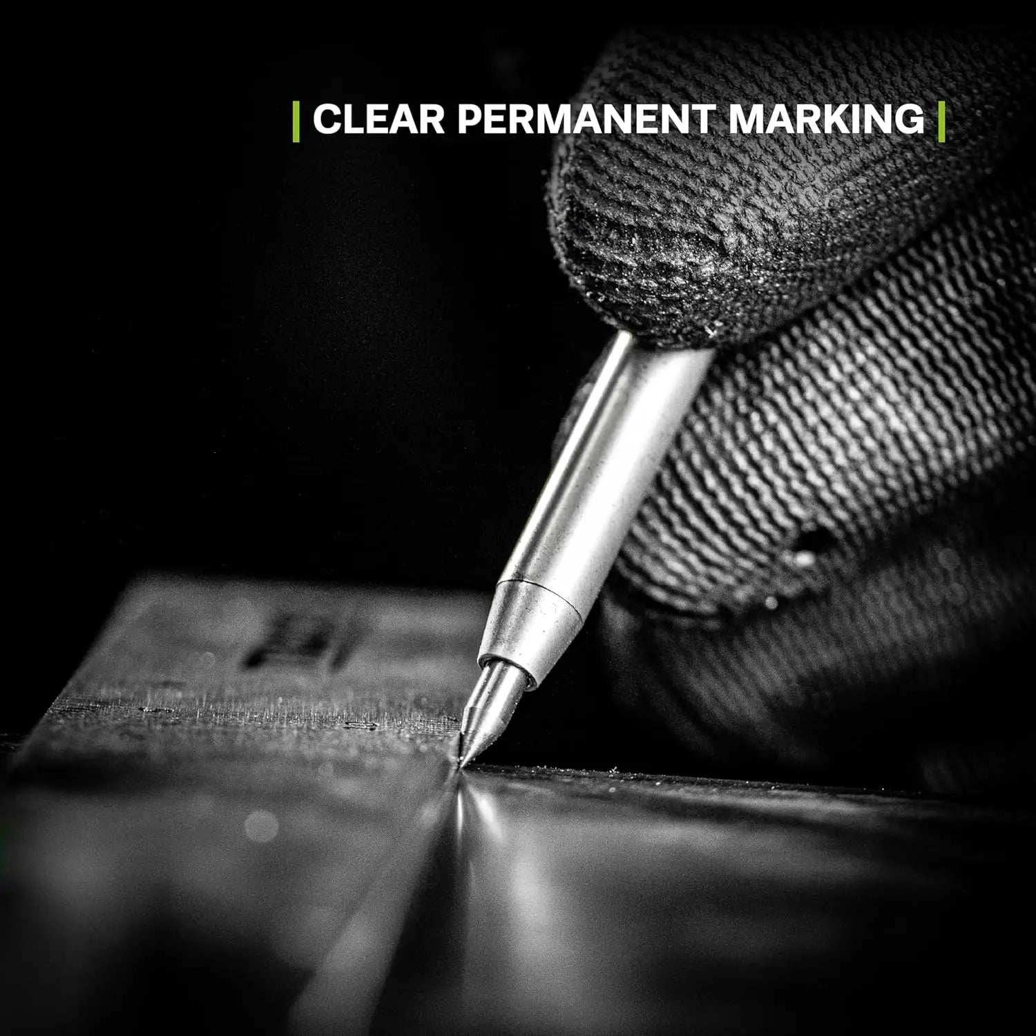 Mână cu mănușă ținând un scriptor din carbură tipped pe suprafață metalică pentru marcaj permanent